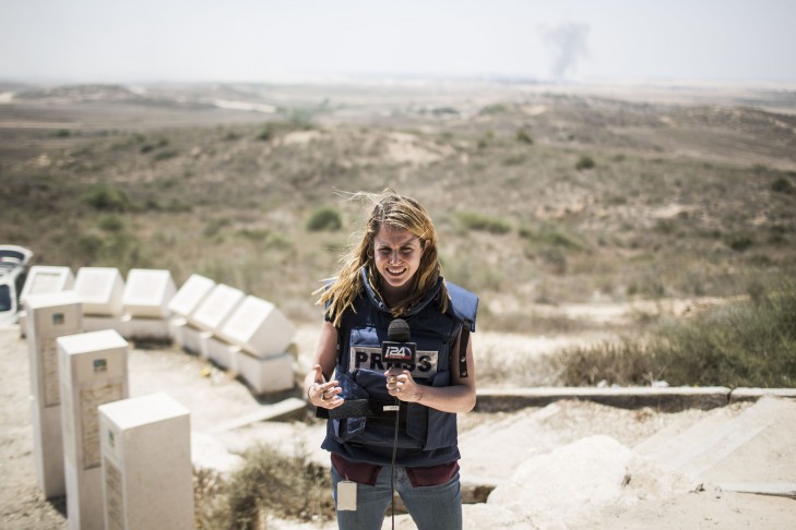 A TV reporter does a stand-up near the Israeli/Gaza border (Photo by Ilia Yefimovich/Getty Images)