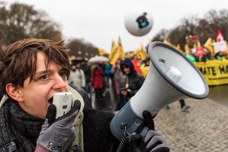 An activist speaks into a megaphone during the Global Climate March on November 29, 2015 in Berlin, Germany  (Photo by Carsten Koall/Getty Images)