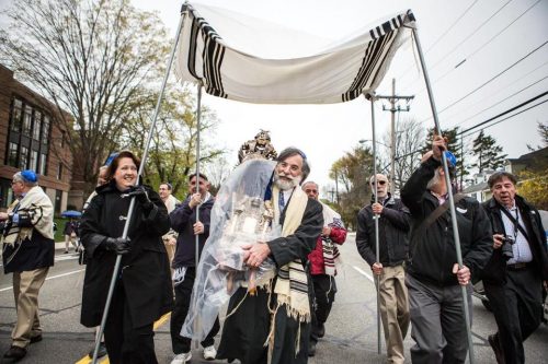 David Ehrmann carried a Torah scroll during a one-mile parade to dedicate Congregation Beth Shalom of the Blue Hills' new synagogue in Milton. (Aram Boghosian for The Boston Globe)