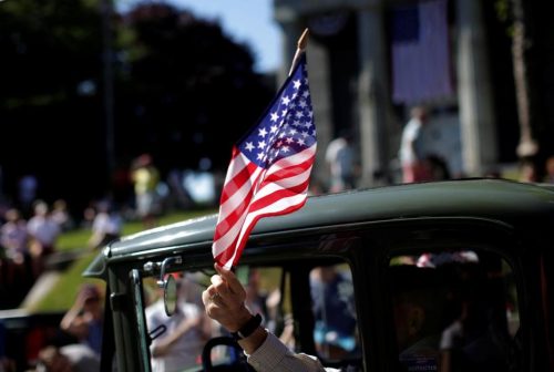 A man waves an American flag in the Independence Day parade in Barnstable. (MIKE SEGAR/REUTERS)