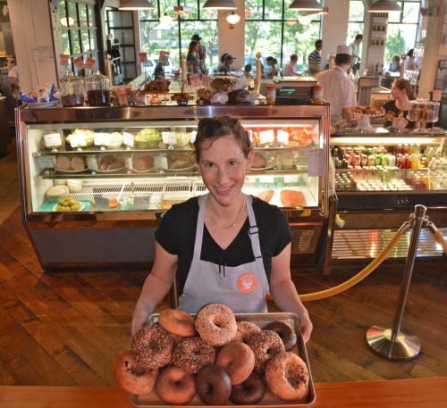 With the deli and restaurant as a backdrop, Mamaleh's Pastry Chef and partner Rachel Sundet presents some fresh made bagels and bialys. (Credit: Chris Christo)