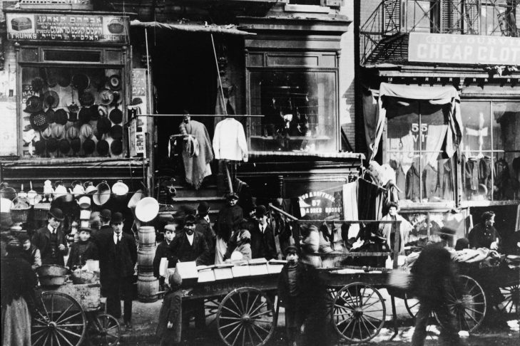 Shoppers in the mostly Jewish immigrant poplulation congregate as vendors sell their wares on the sidewalk outside of haberdasheries at 57 Hester Street and 55 Hester Street on the Lower East Side of Manhattan, New York circa 1900 (Photo by Hulton Archive/Getty Images)