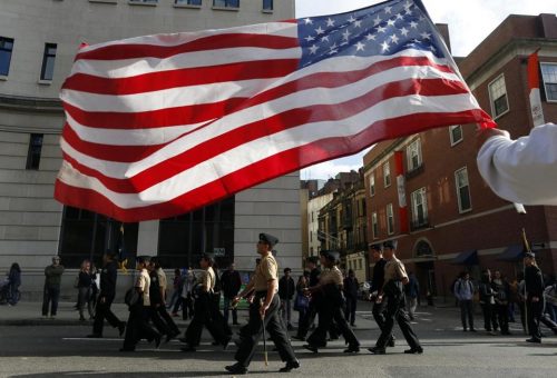 A man holds an American flag during a Veterans Day Parade in Boston. (JESSICA RINALDI/THE BOSTON GLOBE)