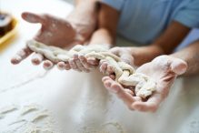Father and son holding a braid of dough (Photo: mediaphotos/iStock)