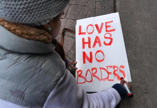 Tori Furtado wrote a sign for a Boston rally that protested President Donald Trump’s immigration policies on Saturday. (JOHN TLUMACKI/GLOBE STAFF)