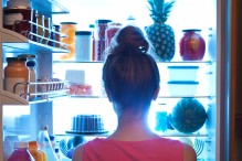 Woman looking for food to eat in the refrigerator (Photo: YinYang/iStock)