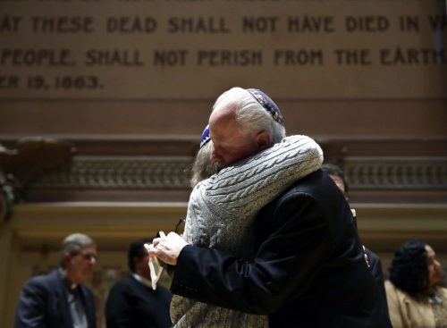 Rabbi Jeffrey Myers of Tree of Life/Or L'Simcha Congregation hugs Rabbi Cheryl Klein of Dor Hadash Congregation on the stage in Soldiers & Sailors Memorial Hall & Museum during a community gathering held in the aftermath of a deadly shooting at the Tree of Life Synagogue in Pittsburgh, Sunday, Oct. 28, 2018. (AP Photo/Matt Rourke)