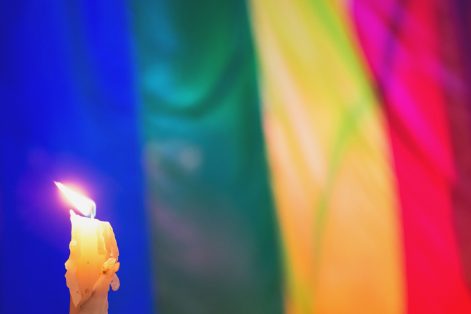 Candle and LGBTQI pride flag (Photo: shaunl/iStock)