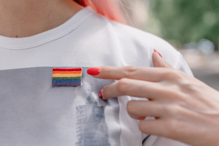 Female hand with red nails points to lgbt sign. LGBTQ, lgbt gay pride tolerance concept.