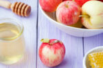 Honey, honeycombs and fresh apples on a lavender wooden background Top view