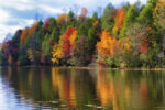 Colorful fall colors reflect along the shoreline of Bay Mountain Lake Park in Kingsport Tennessee.