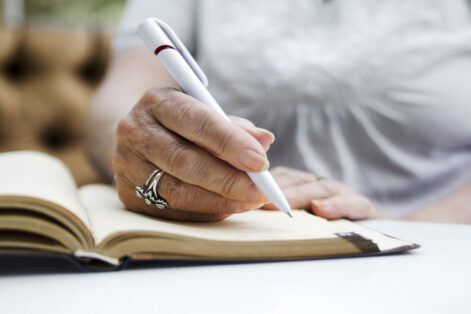 journaling notebook writing Old female hands on paper note writing a testament document