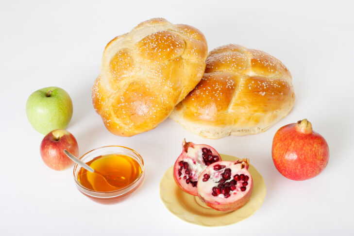 Round challah with pomegranates, apples and honey, traditional food eaten on Rosh Hashana, the Jewish New Year.