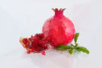 Pomegranate in polygonal crystal style on light background. Formed by triangles.