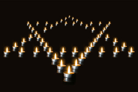 The star of David lined with candles in the night, on a black background. Burning candles - a symbol of International Holocaust Remembrance day 27 January