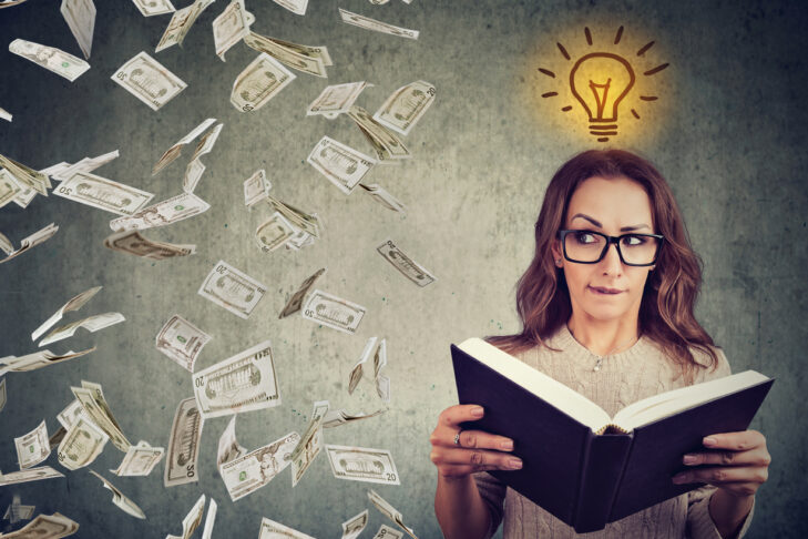 Woman student reading a book has a bright idea how to earn money