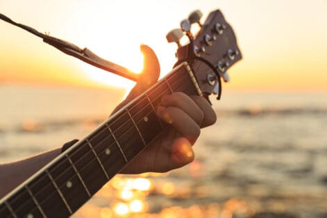 Young guy playing a guitar at sunset(Soft Focus)
