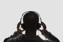 Male silhouette with headphones on white background.