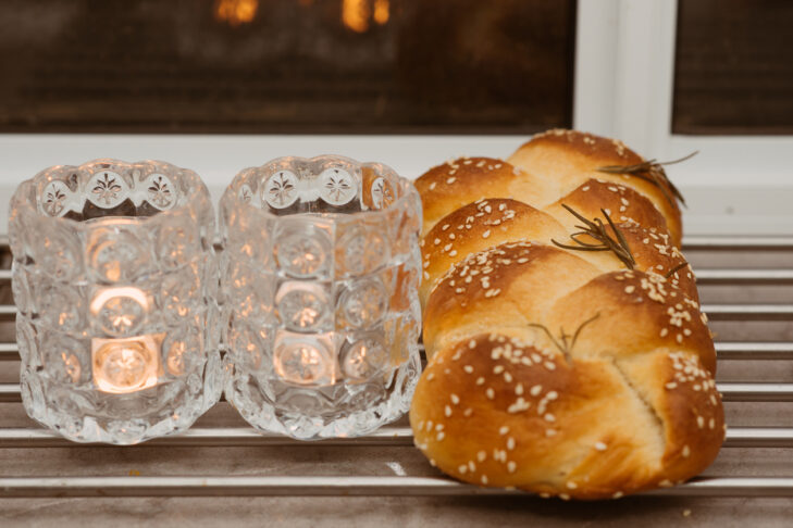 Jewish Sabbath with challah handmade tasty bread and candle.