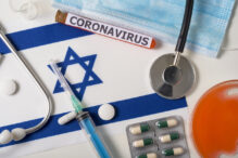 Coronavirus, nCoV concept. Top view of a protective breathing mask, stethoscope, syringe, pills on the flag of Israel. A new outbreak of the Chinese coronavirus