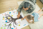 Lying on floor. Top view of caring father and daughter lying on the floor and painting family tree