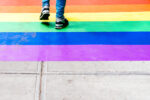 Feet Walking on Sidewalk Decorated with Rainbow Flag. Lesbian, Gay, Bisexual, Pansexual, Asexual, Queer, LGBTQ and LGBTQ plus concepts