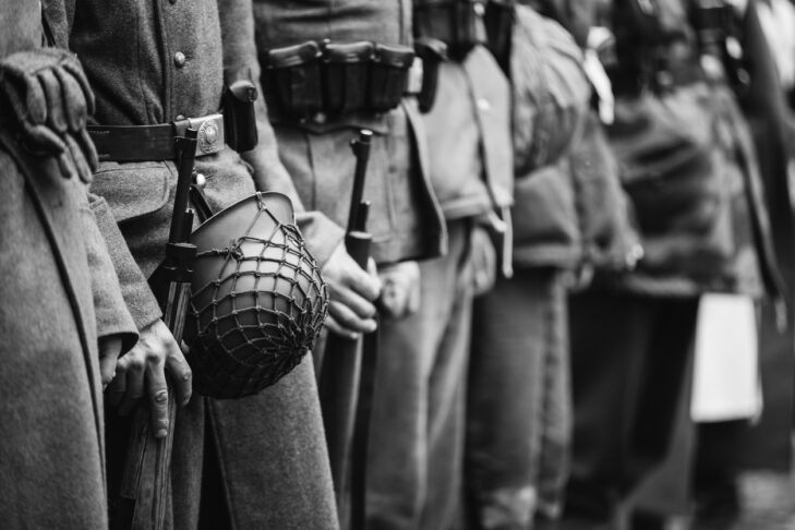 Close Up Of German Military Ammunition Of A German Soldier. Unidentified Re-enactors Dressed As World War II German Soldiers Standing Order. Photo In Black And White Colors. Soldiers Holding Weapon Rifles
