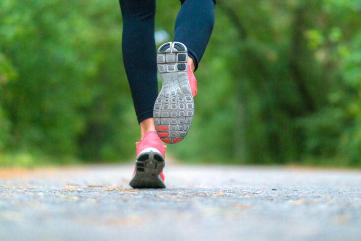 Running woman in the forest. Close-up of sneakers. Healthy lifestyle concept.