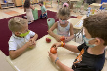 1st Graders in a classroom examining apples