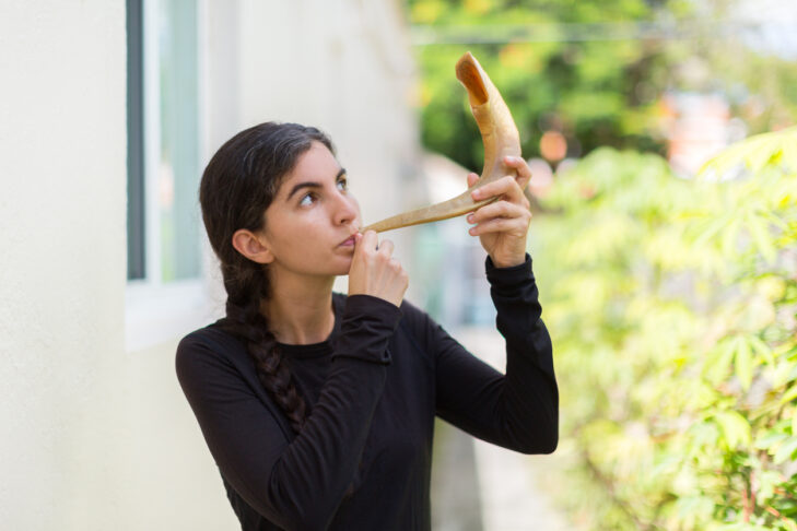 Woman blowing shofar for Rosh Hashana