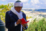 Jerusalem, Israel - November 11, 2015: An Ethiopian Jewish man pray at the Sigd, with the old city in the background, in Jerusalem, Israel. The Sigd is an annual holiday of the Ethiopian Jewry
