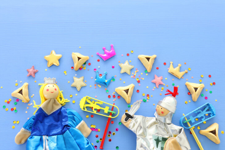Purim celebration concept (jewish carnival holiday) over blue wooden background. Top view, Flat lay