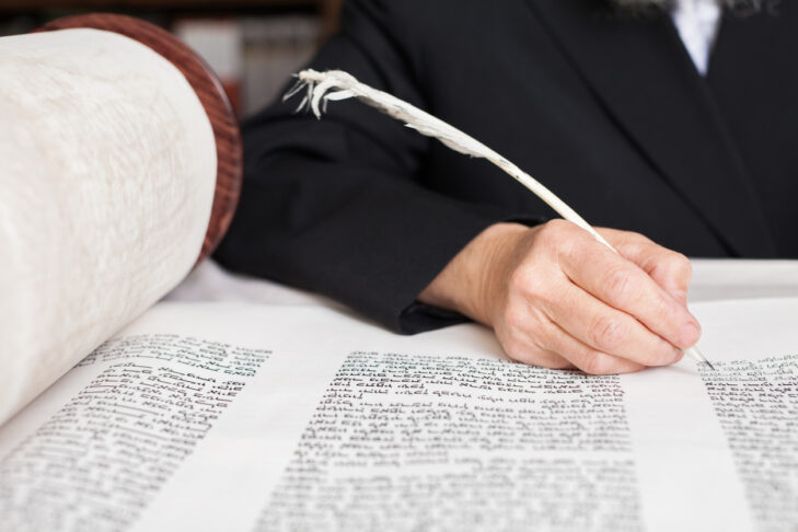 Scribe finishing writing in a Torah scroll