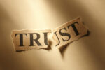 The word "Trust" torn in half.