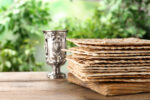 Traditional Matzos and silver goblet on wooden table, space for text. Pesach (Passover) celebration