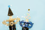 Holiday background, masks and champagne on a light blue background. Carnival concept, Purim background. Top view, copy space
