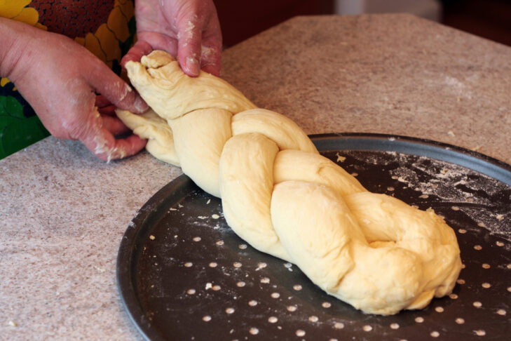 A woman braiding challah (a Jewish braided bread).All images in this series...
