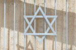 Metal Star of David (Magen David) Jewish symbol at welded metal fence, close up