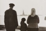 Photo shows immigrant family looking at Statue of Liberty from Ellis Island.c1930