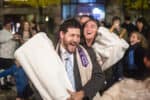 Temple Israel clergy and congregants dancing in the street with the Torah on Simchat Torah
