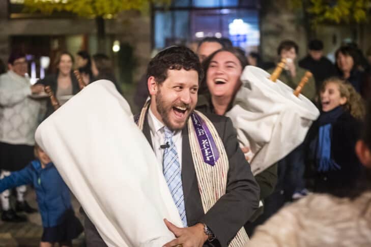 Temple Israel clergy and congregants dancing in the street with the Torah on Simchat Torah