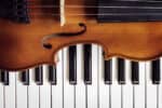Violin on top of piano keyboard background with copy space for music concept
