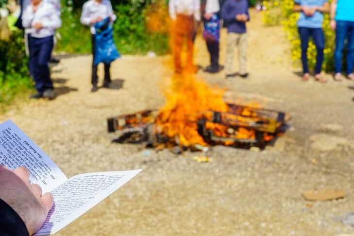 Haifa, Israel - April 19, 2019: Jewish man read a blessing, part of a Biur (burning) Chametz (leavened foods) ceremony, in Haifa, Israel. This is part of the Passover holiday traditions