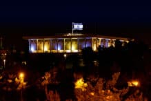 Knesset the Parliament of Israel with flying waving flag of Israel at night