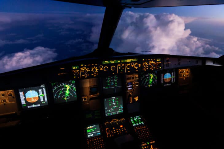 Airbus 320 airliner flightdeck at sunset with a thunderstorm in the distance and a thunderstorm displayed on the aircraft's weather radar screen
