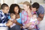 Parents, Parenting group, baby, babies, newborns Two Young Family With Babies Sitting On Sofa At Home