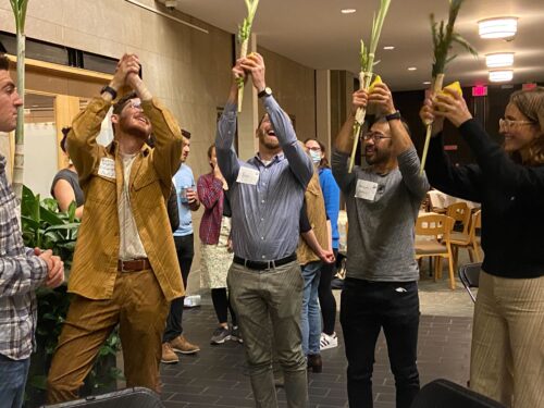 Young adults shaking the lulav at Temple Israel of Boston with Rabbi Oberstein