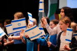Rashi students sing "Hatikvah" (The Hope), Israel's national anthem while waiving flags