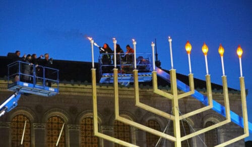Boston, MA - December 5: Concluding a ceremony in Copley Square in Boston, Boston City Councilor Kenzie Bok lit a giant menorah on the last day of Hanukkah on December 5, 2021. Two lifts carried participants, including Governor Charlie Baker, up for the lighting. (Photo by Pat Greenhouse/The Boston Globe via Getty Images)