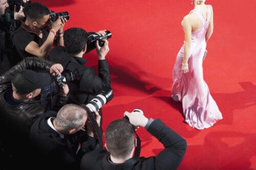 Paparazzi taking pictures of celebrity on red carpet
